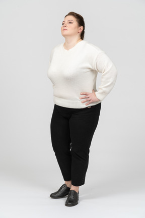 Confident plump woman in white sweater posing
