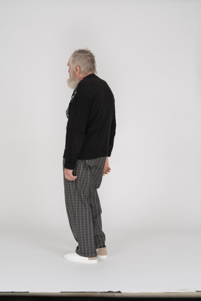 Three-quarter back view of an old man standing