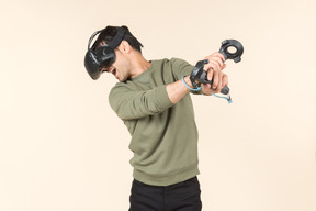 Young caucasian guy playing a virtual reality game