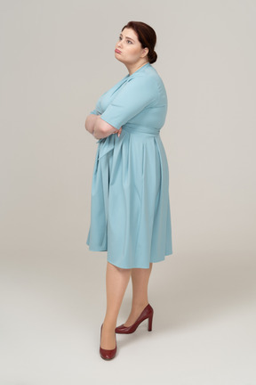 Mulher triste de vestido azul em pé de perfil