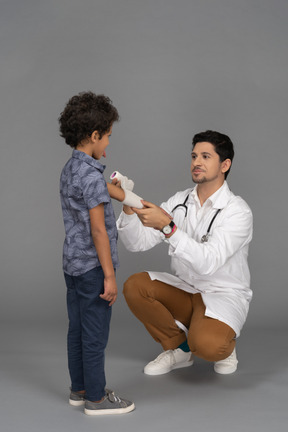 Doctor mostrando vendaje al niño