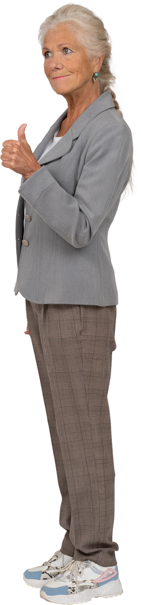 Side view of a happy old lady in suit showing thumb up