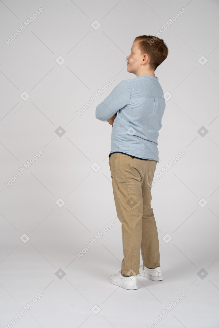 Junge posiert mit verschränkten armen und schaut nach oben