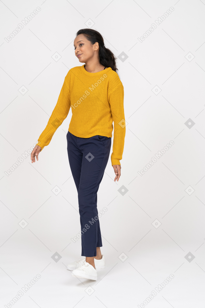 Front view of a happy girl in casual clothes standing with outstretched arms