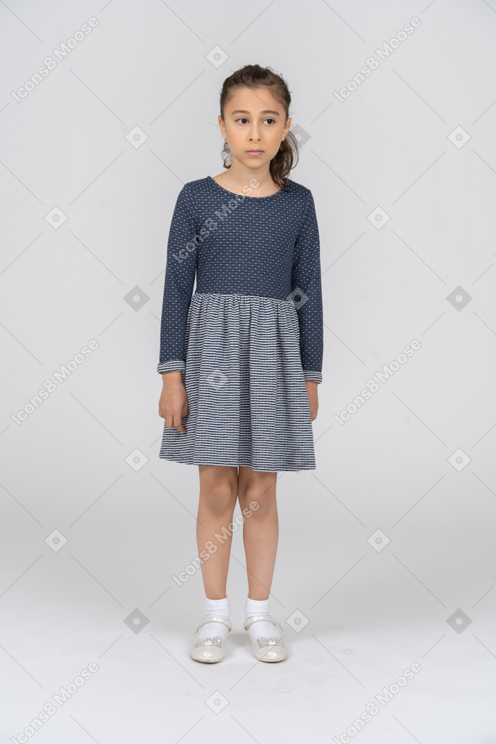 一个穿着灰色裙子站着的女孩的全长