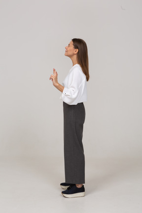 Side view of a young lady in office clothing crossing fingers
