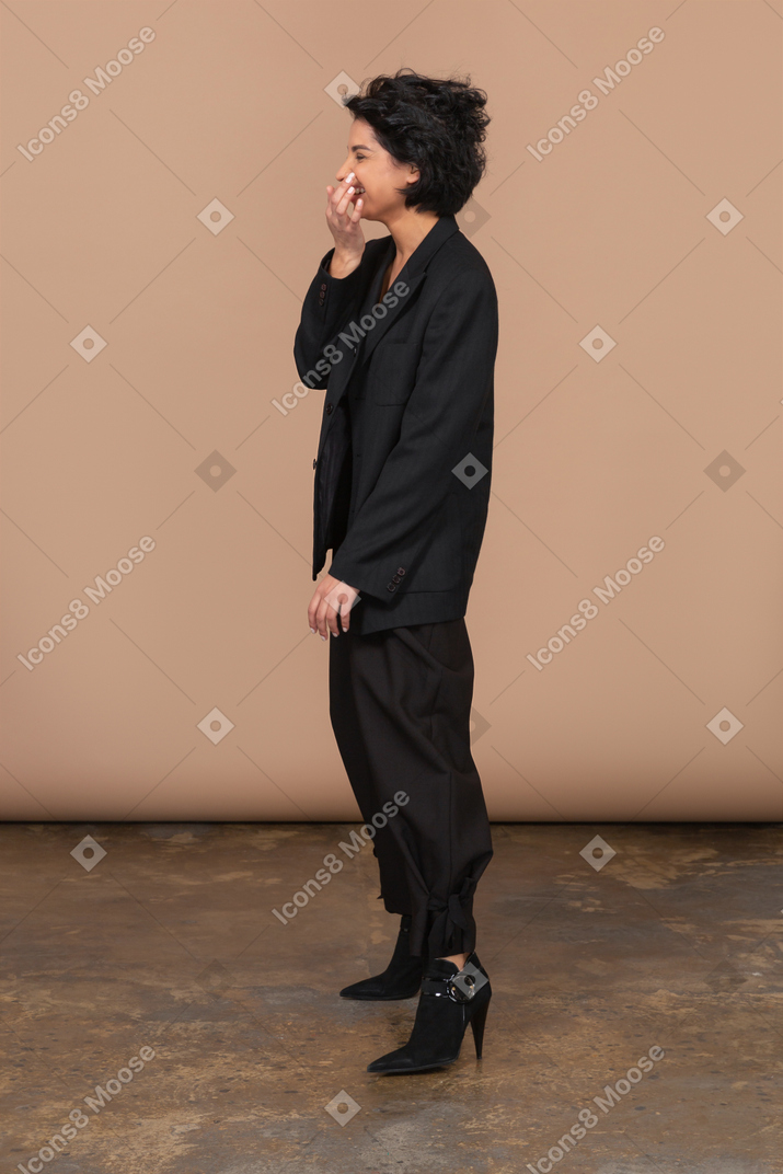 Side view of a laughing businesswoman looking aside and touching nose