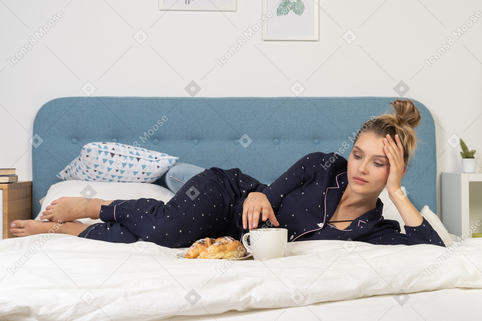 一位躺在床上吃早餐的年轻女士的前视图