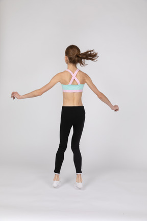 Side view of a teen girl in sportswear squatting and putting hands on hips