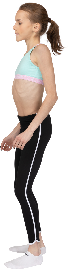 Vista lateral de una jovencita en ropa deportiva inclinando los hombros
