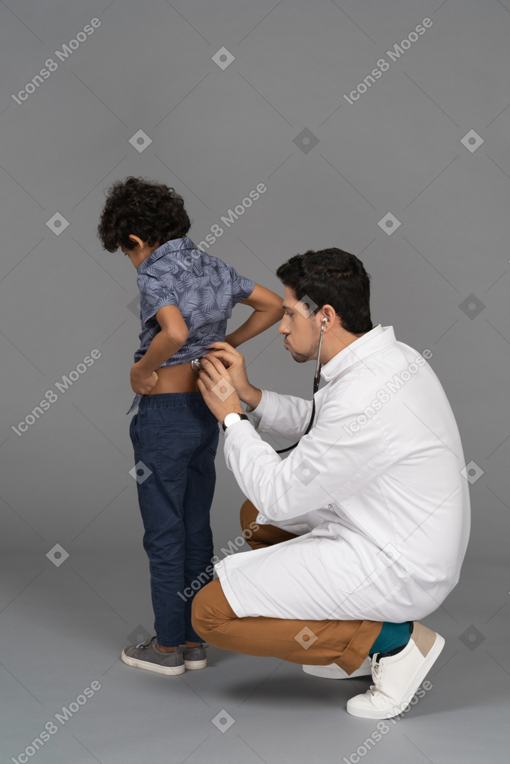 Médico con estetoscopio examinando a un niño