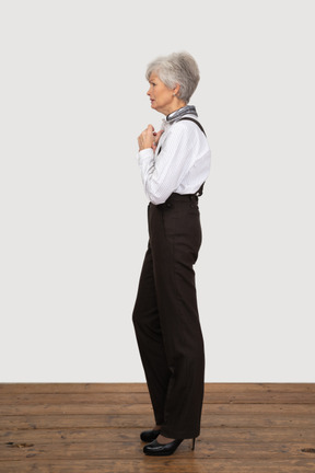 Vista lateral de uma senhora preocupada com roupa de escritório, de mãos dadas
