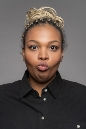 Young dark-skinned woman with pursed lips facing the camera