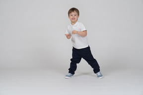 Front view of a smiling little boy standing