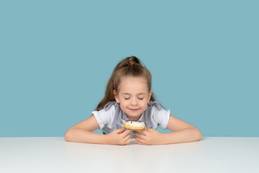 Niña linda mirando un donut