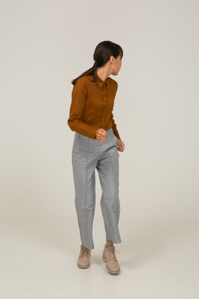 Front view of a running young asian female in breeches and blouse turning away