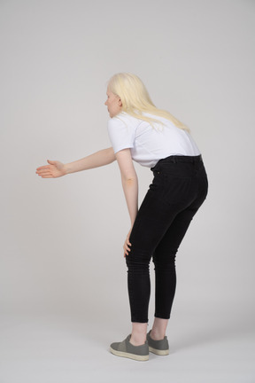 Back view of a woman bending forward and reaching out arm