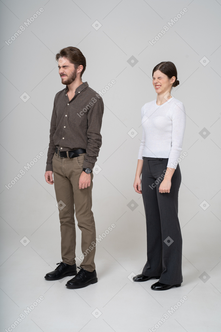 Three-quarter view of a grimacing displeased young couple in office clothing