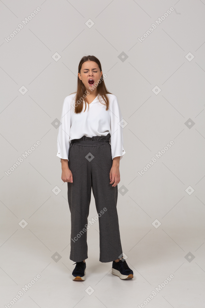 一位穿着办公室服装、打着哈欠的年轻女士的前视图