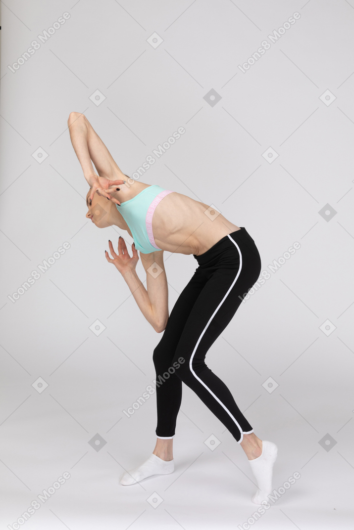 Вид сбоку девушки в спортивной одежде, наклонившейся вперед и жестикулирующей