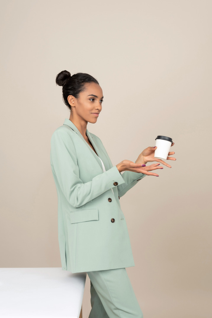 Young businesswoman standing with a cup of coffee