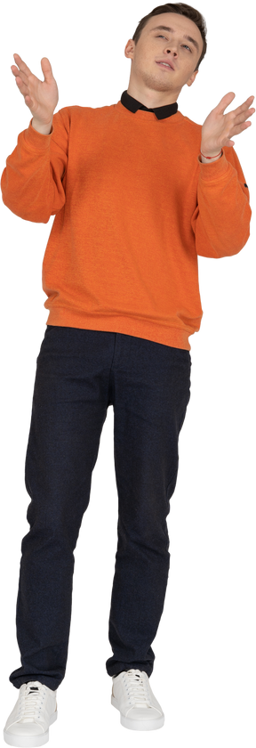 Young man in orange sweatshirt standing