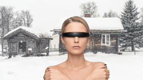 Woman with futuristic glasses in front of winter house