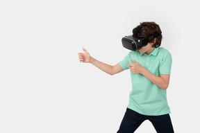 Boy in vr headset holding invisible weapon