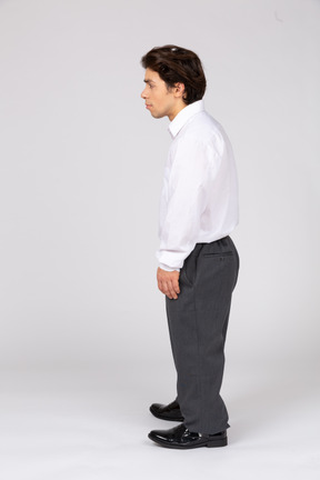 Side view of young man standing and looking aside