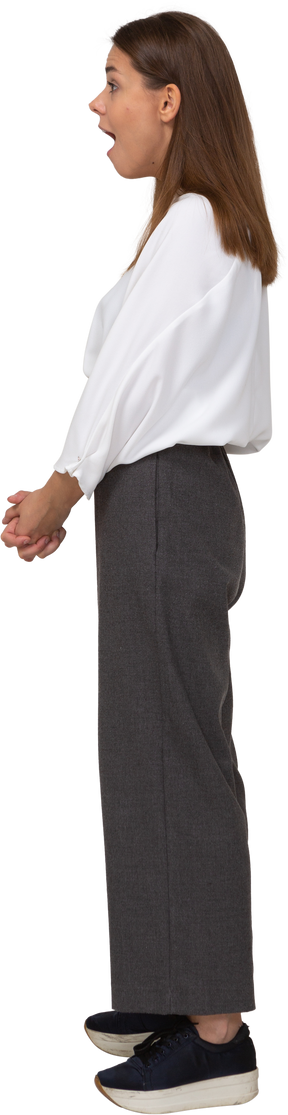 Side view of a shocked young lady in office clothing holding hands together