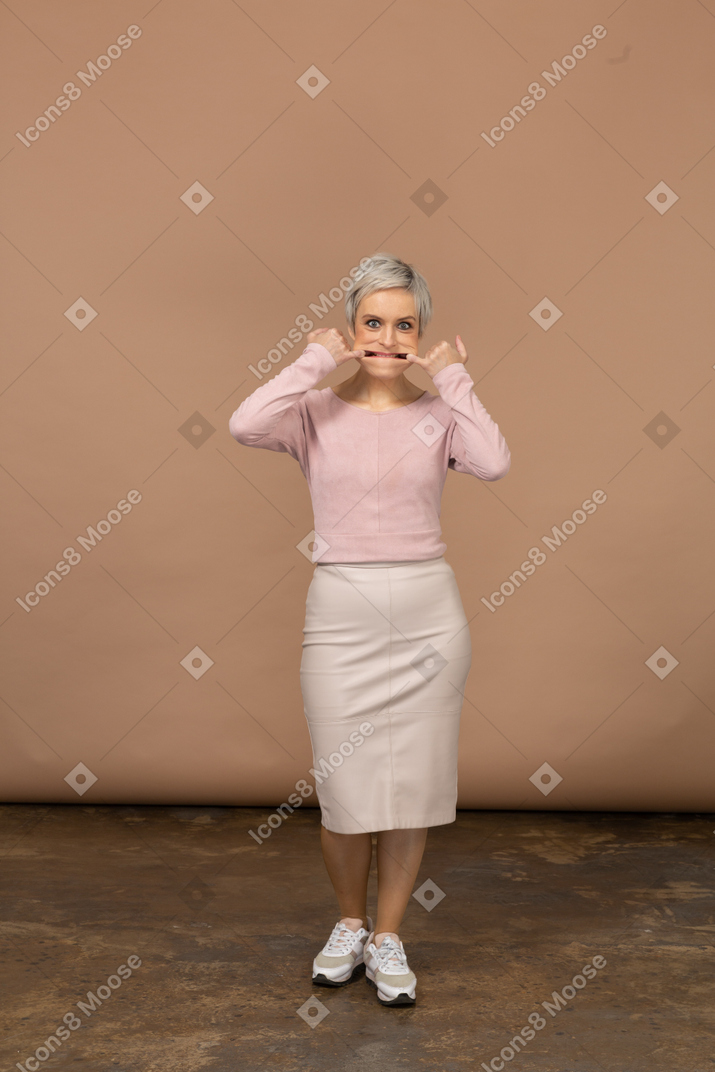 Vista frontale di una donna in abiti casual che si mette le dita in bocca