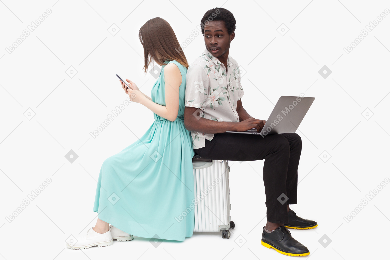Interracial couple sitting on suitcase and and using gadjets