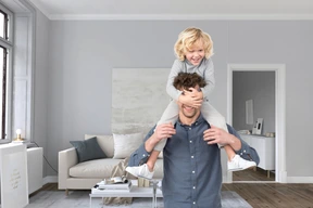 Man holding baby on his shoulders in living room