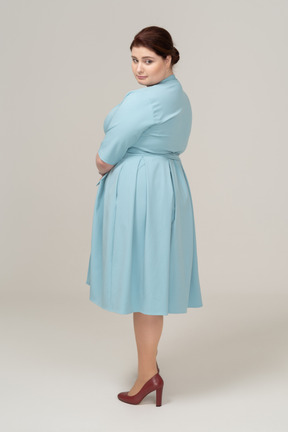 Side view of a woman in blue dress looking down