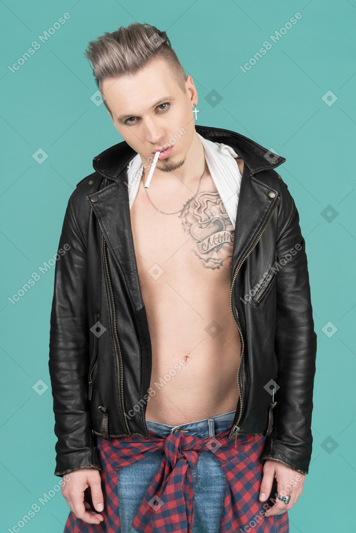 Barefaced punk man with a cigarette standing against camera