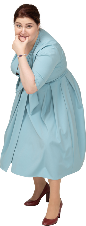 Vista frontal de uma mulher de vestido azul assobiando