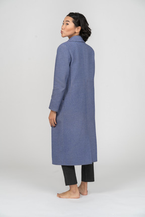 Rear view of a woman with puckered lips in coat
