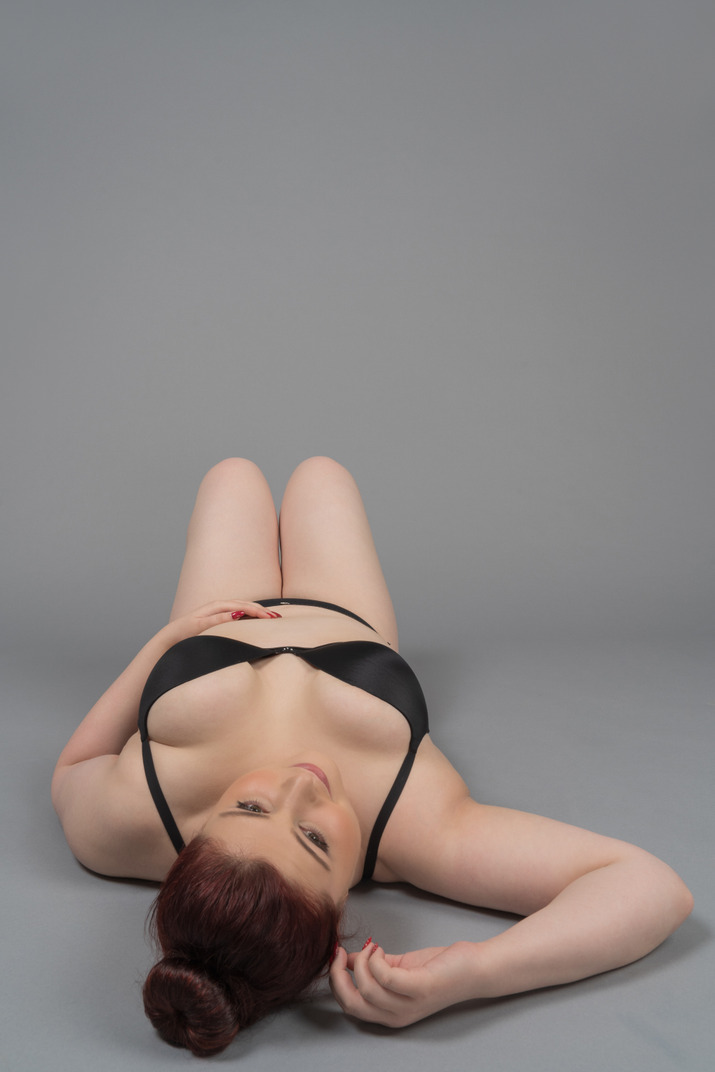 Woman in black lingerie lying on the floor