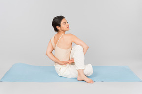Young indian woman sitting on yoga mat