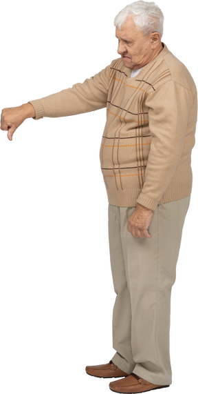 Vista lateral de um velho em roupas casuais, mostrando o polegar para baixo