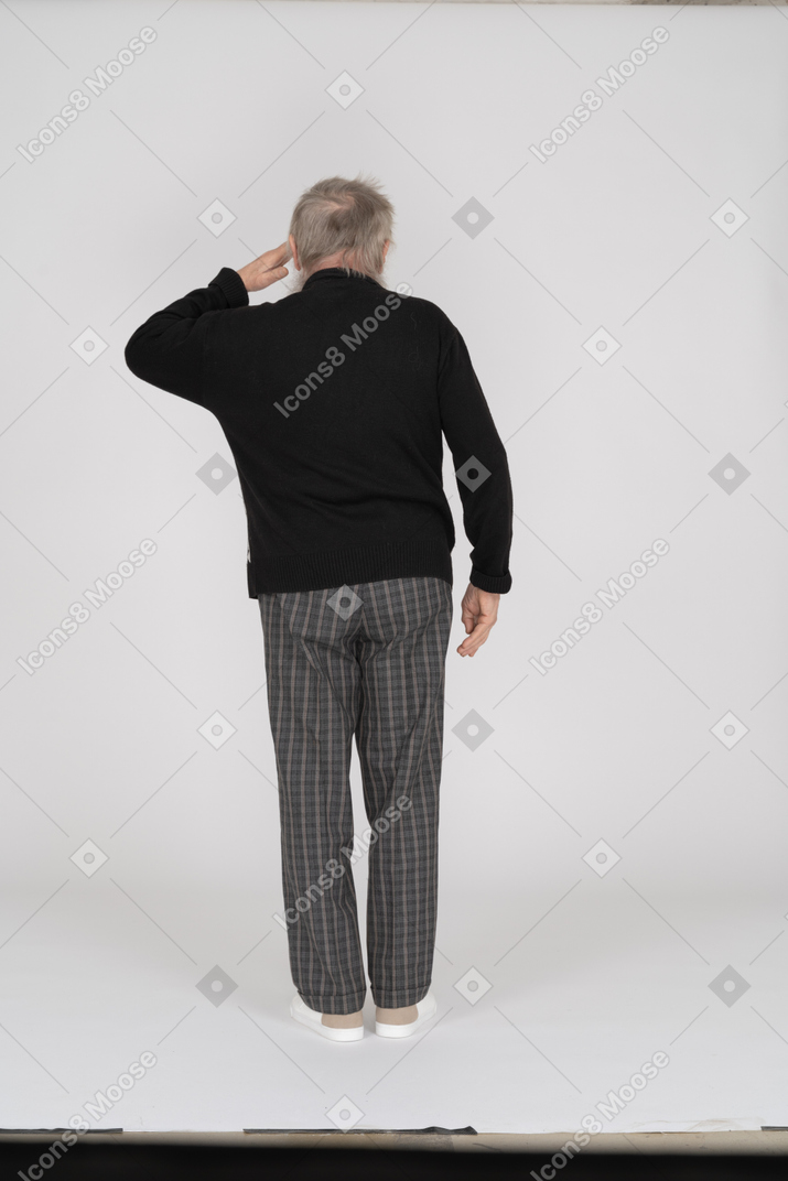 Rear view of old man saluting