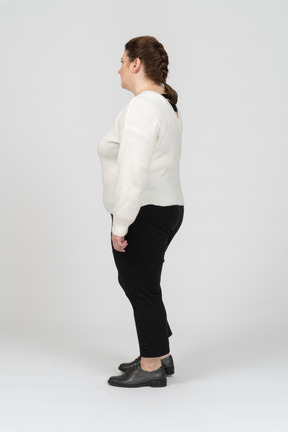 Plump woman in casual clothes standing in profile