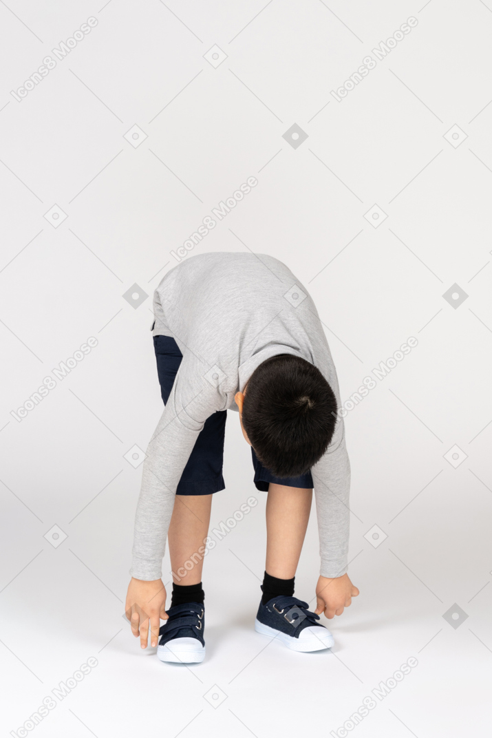 Vista frontal de un niño inclinado hacia adelante