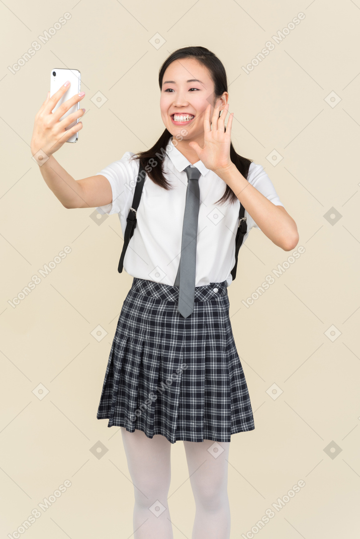 Asiatisches schulmädchen, das ein selfie macht