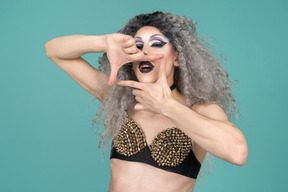 Drag queen finger framing their mouth with eyes closed