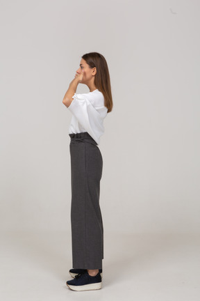 Side view of a young lady in office clothing hiding her mouth