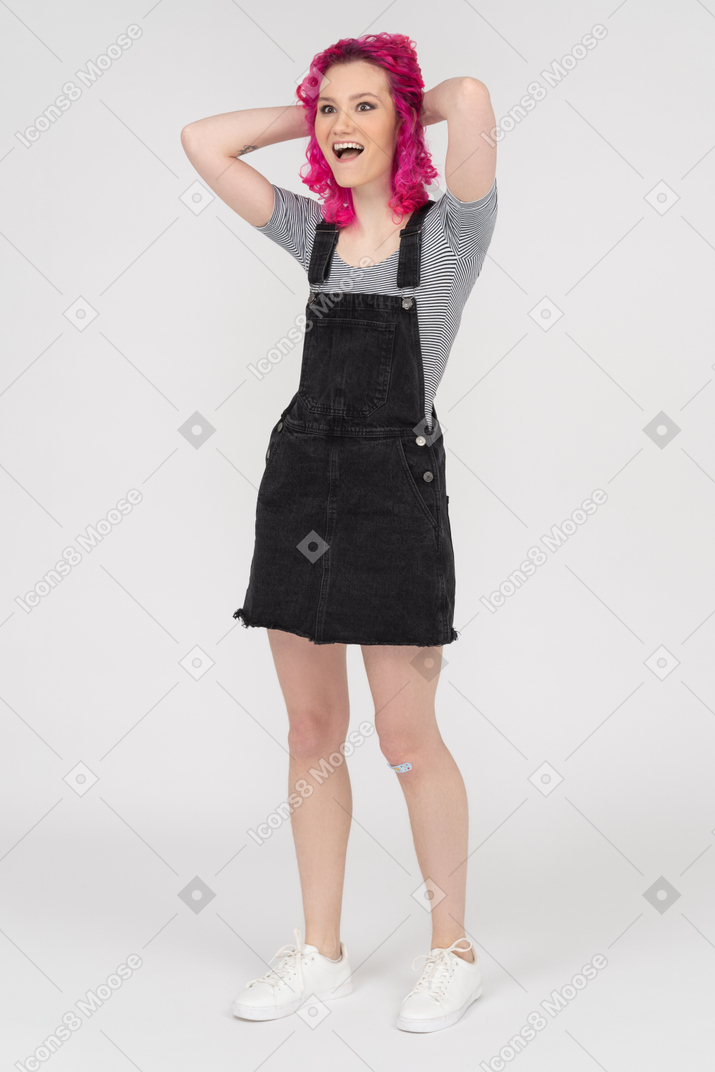 Excited pink haired girl with her hands on the nape looking aside