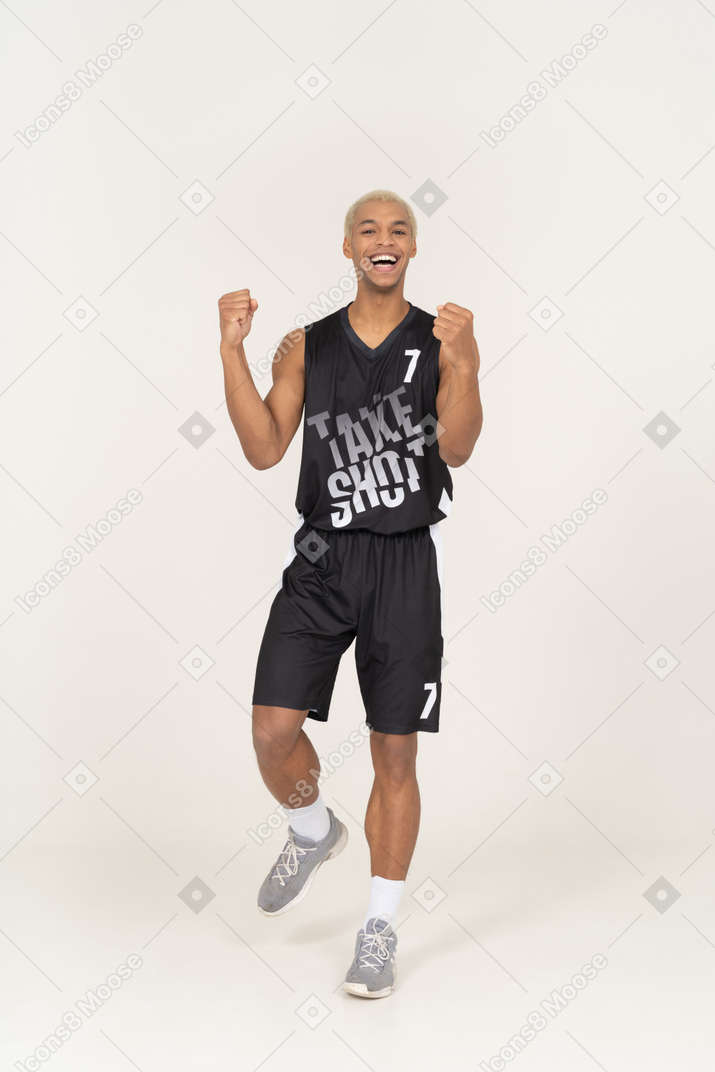 손을 올리는 행복 한 젊은 남자 농구 선수의 전면보기