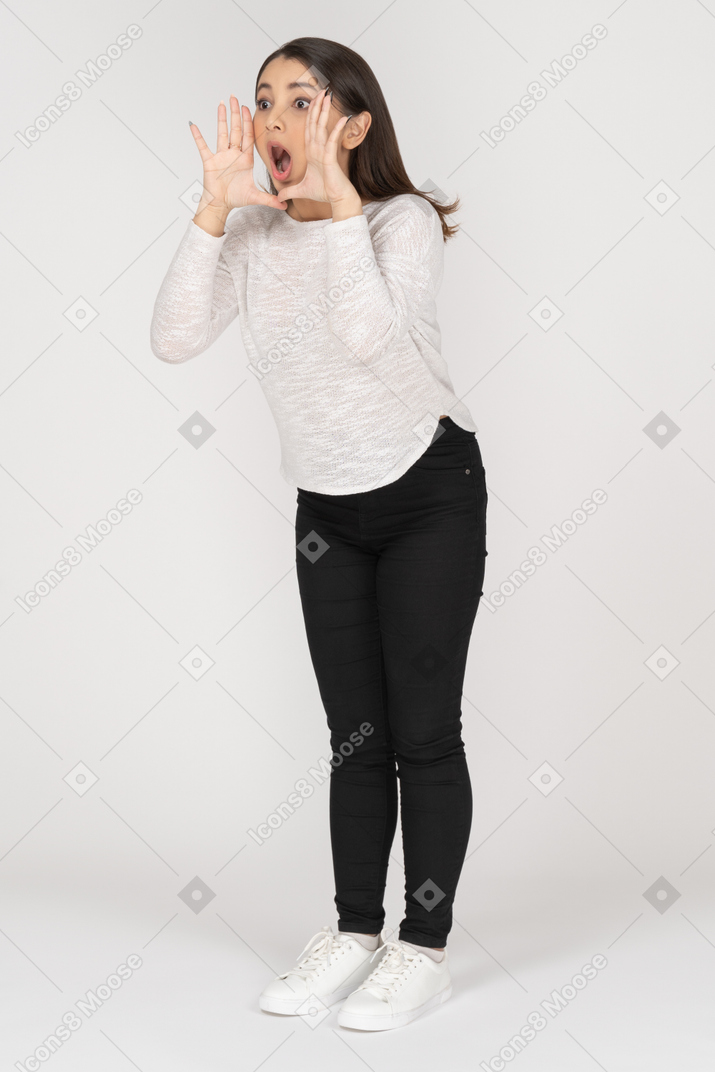 Three-quarter view of a screaming happy young indian female in casual clothing