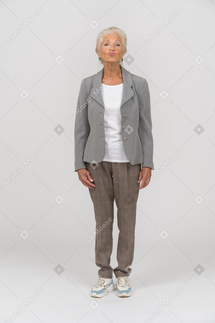 Front view of an old woman in suit blowing a kiss